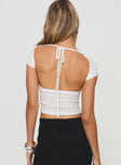 Knit top High neckline, cap sleeves, open back with tie fastening Slight stretch, unlined, sheer