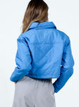 Cropped blue puffer jacket Quilted material Classic collar Press button fastening at front Twin chest pockets