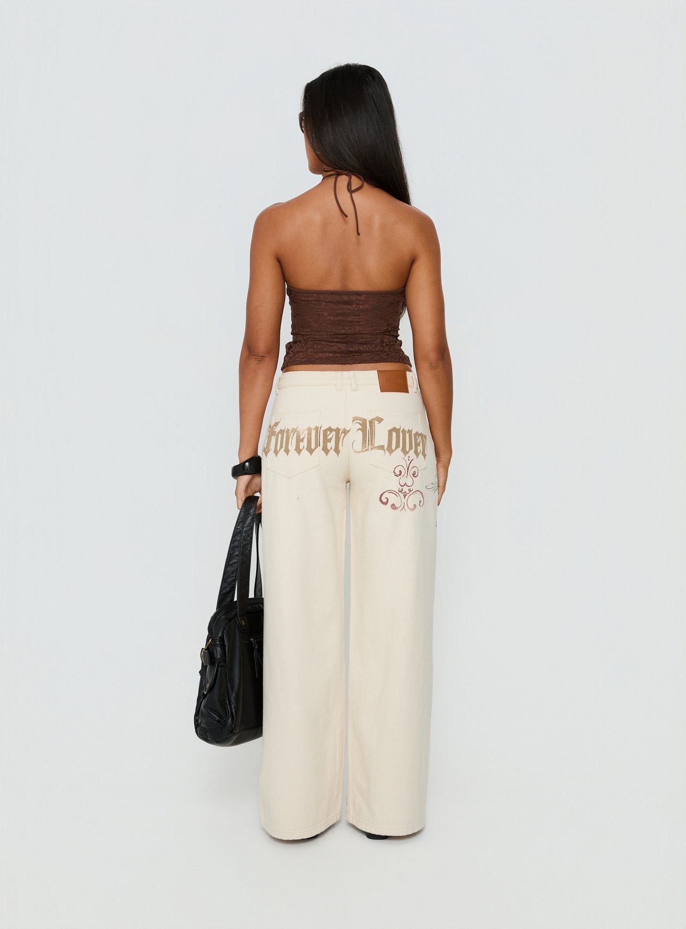 back view of model wearing Princess Polly Than Forever Love Graphic Denim Jeans Cream Low Rise Jeans Jeans 