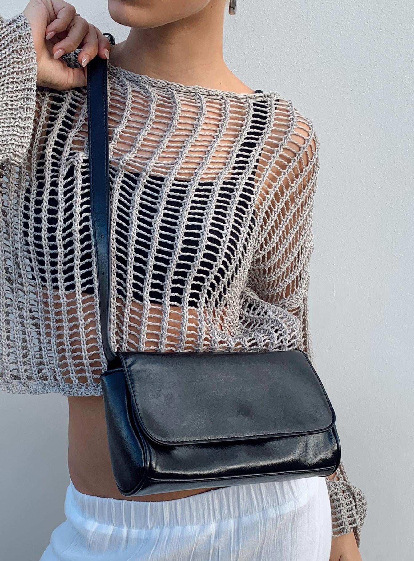 Black shoulder bag Faux leather material  Removable & adjustable shoulder strap  Magnetic button fastening  Single internal pocket  External card slip at back 