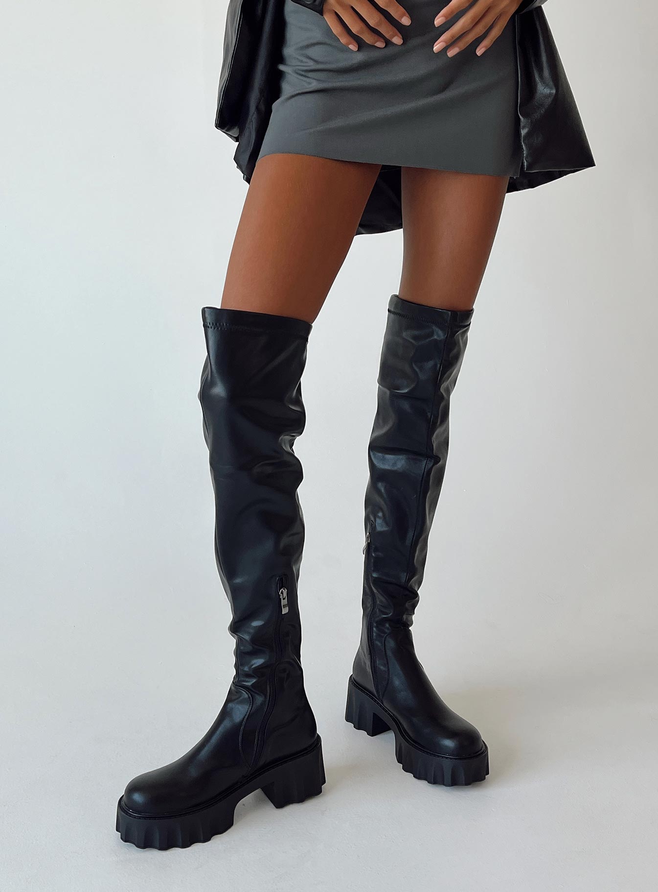 Thigh high boots Faux leather material Platform base Rounded toe Zip fastening at 