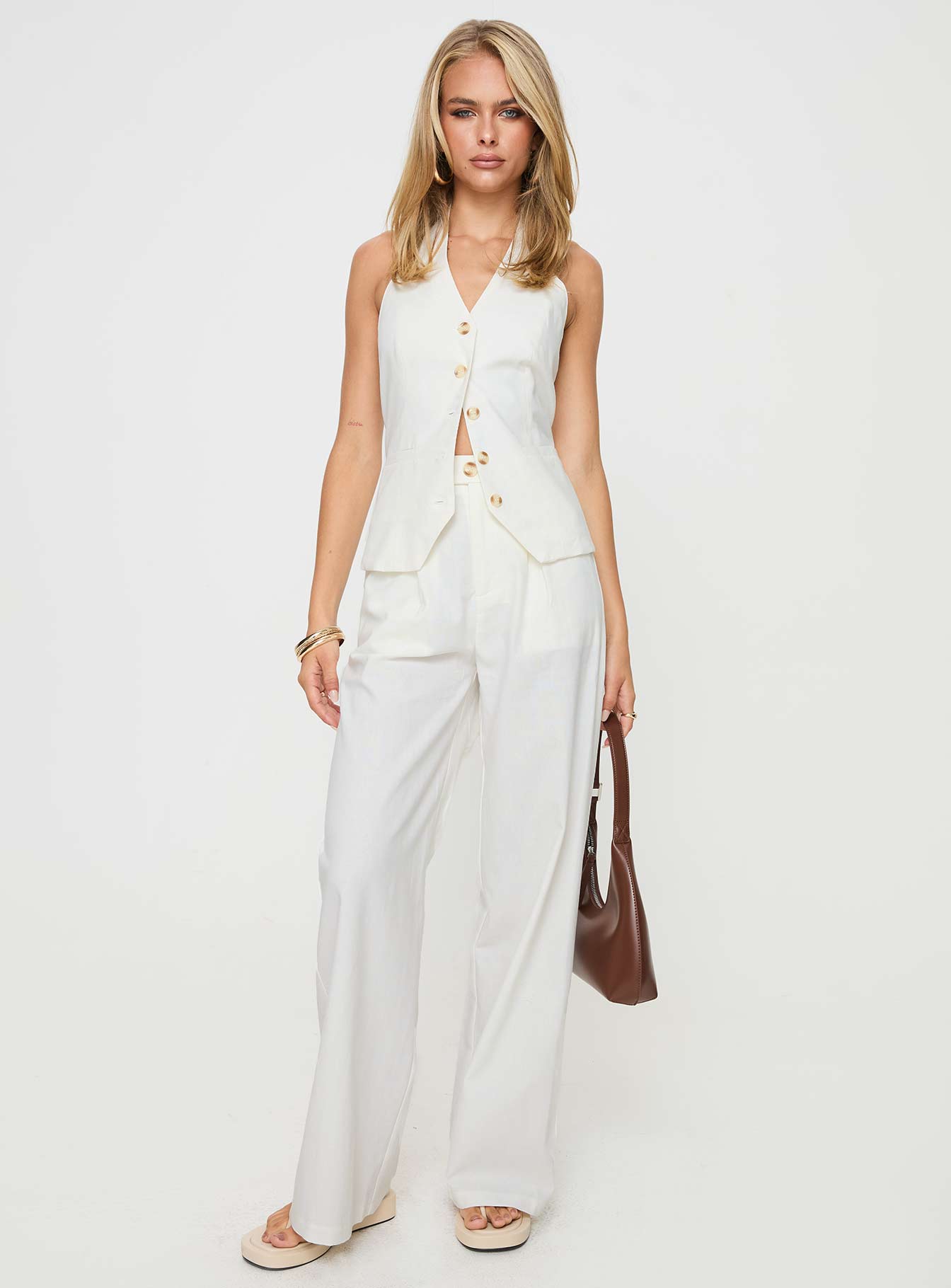 White Matching linen set Halter neck top, fixed halter strap, button fastening at front, twin hip pockets High rise pants, belt looped waist, zip and button fastening, elasticated waistband at back, twin hip pockets, straight leg