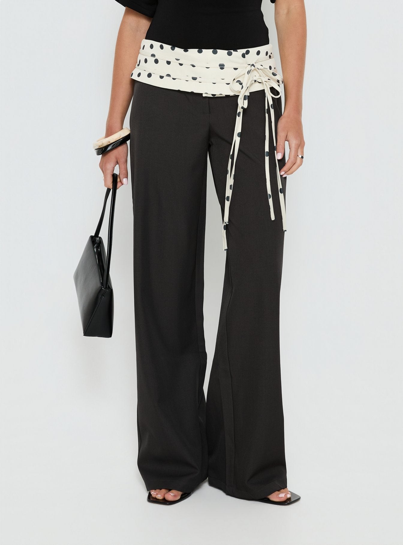 side view of model wearing Princess Polly Seneca Wrap Pants Charcoal Polka Dot Mid Rise Pants 