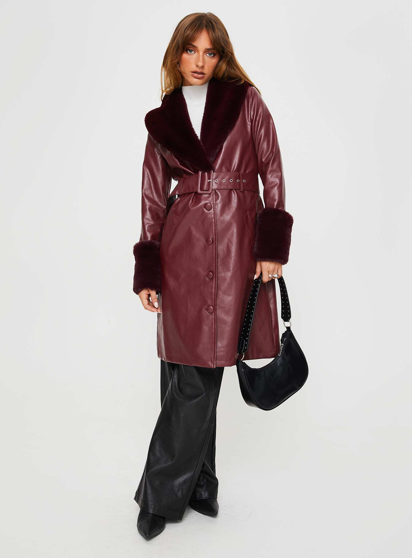Longline coat Faux leather material, faux fur trimming, button front fastening, twin pockets at sides, removable waist belt