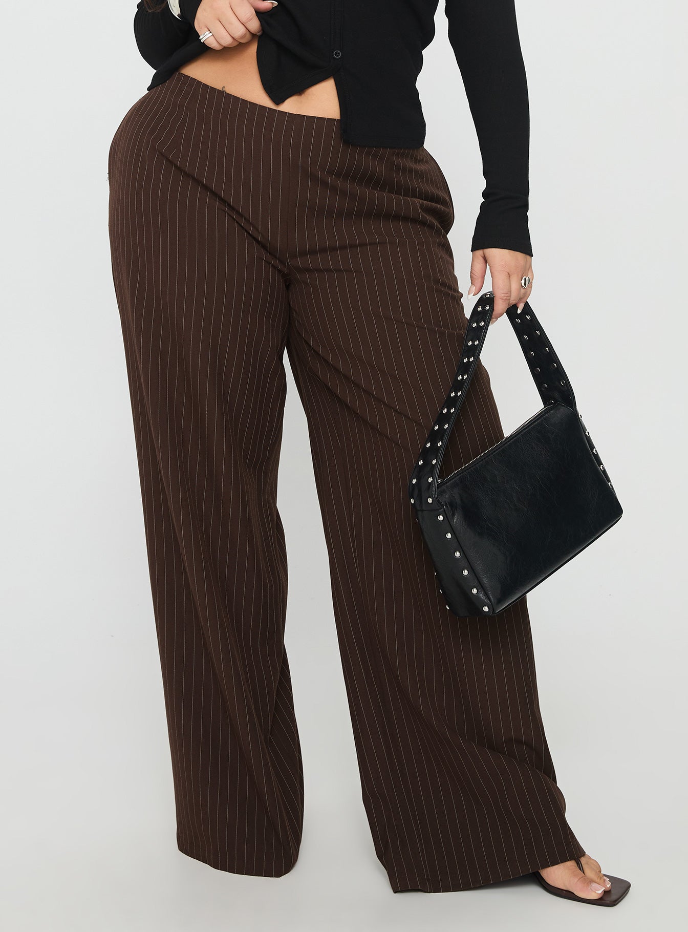 front view of model wearing Princess Polly Khane Low Rise Wide Leg Pant Brown Pinstripe Curve Low Rise Pants 