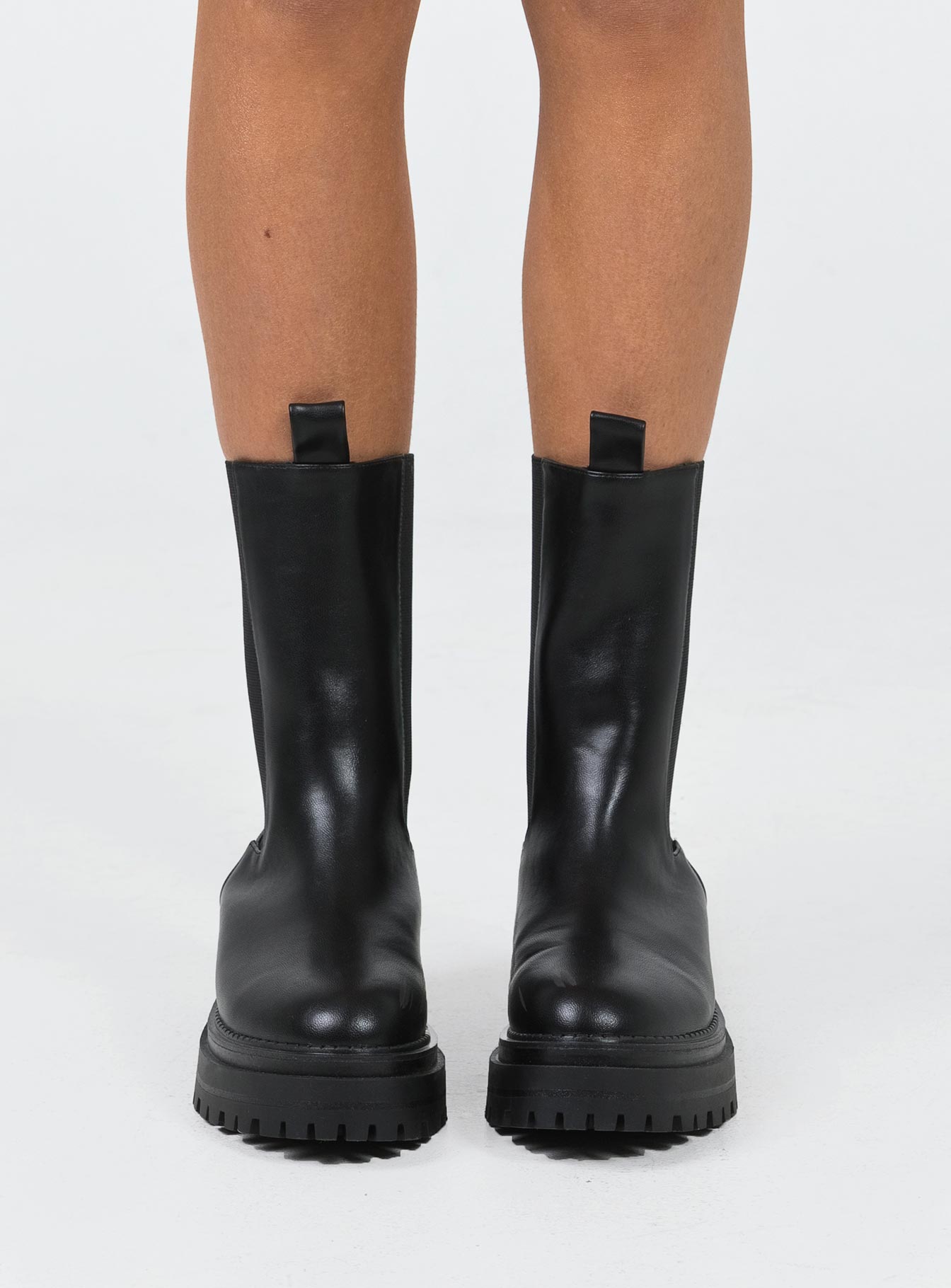 Boots Faux leather material Rounded toe Platform base Ankle pull tab Slip on style