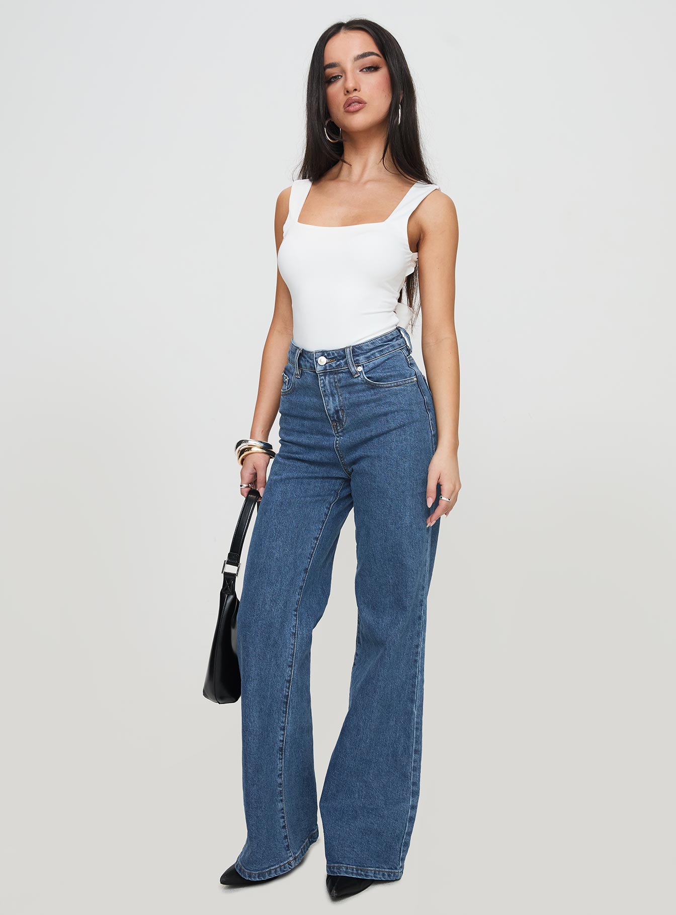 side view of model wearing Princess Polly Lucille High Rise Flare Leg Jeans Mid Wash High Waisted 