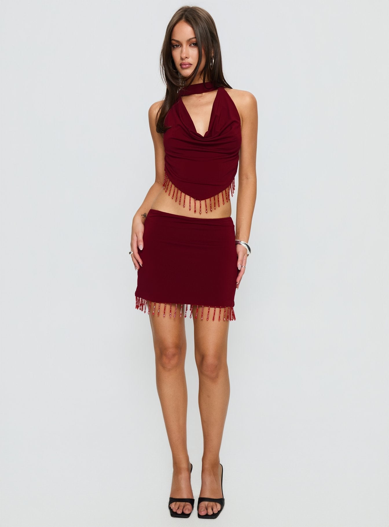   side view of model wearing Princess Polly Ginah Bead Tassel Mini Skirt Red Mini Skirts 