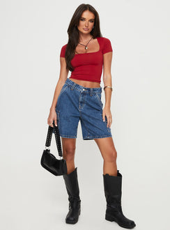 front view of model wearing Princess Polly Mika Carpenter Denim Shorts Mid Wash Petite High Waisted Shorts Low Rise Shorts 