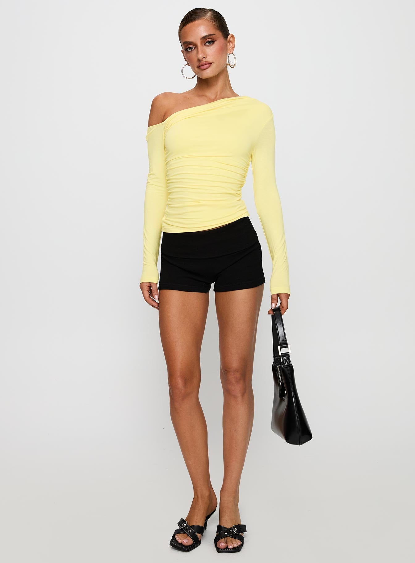 back view of model wearing Princess Polly Beller Long Sleeve Top Lemon Full Sleeves Asymmetric Neckline 