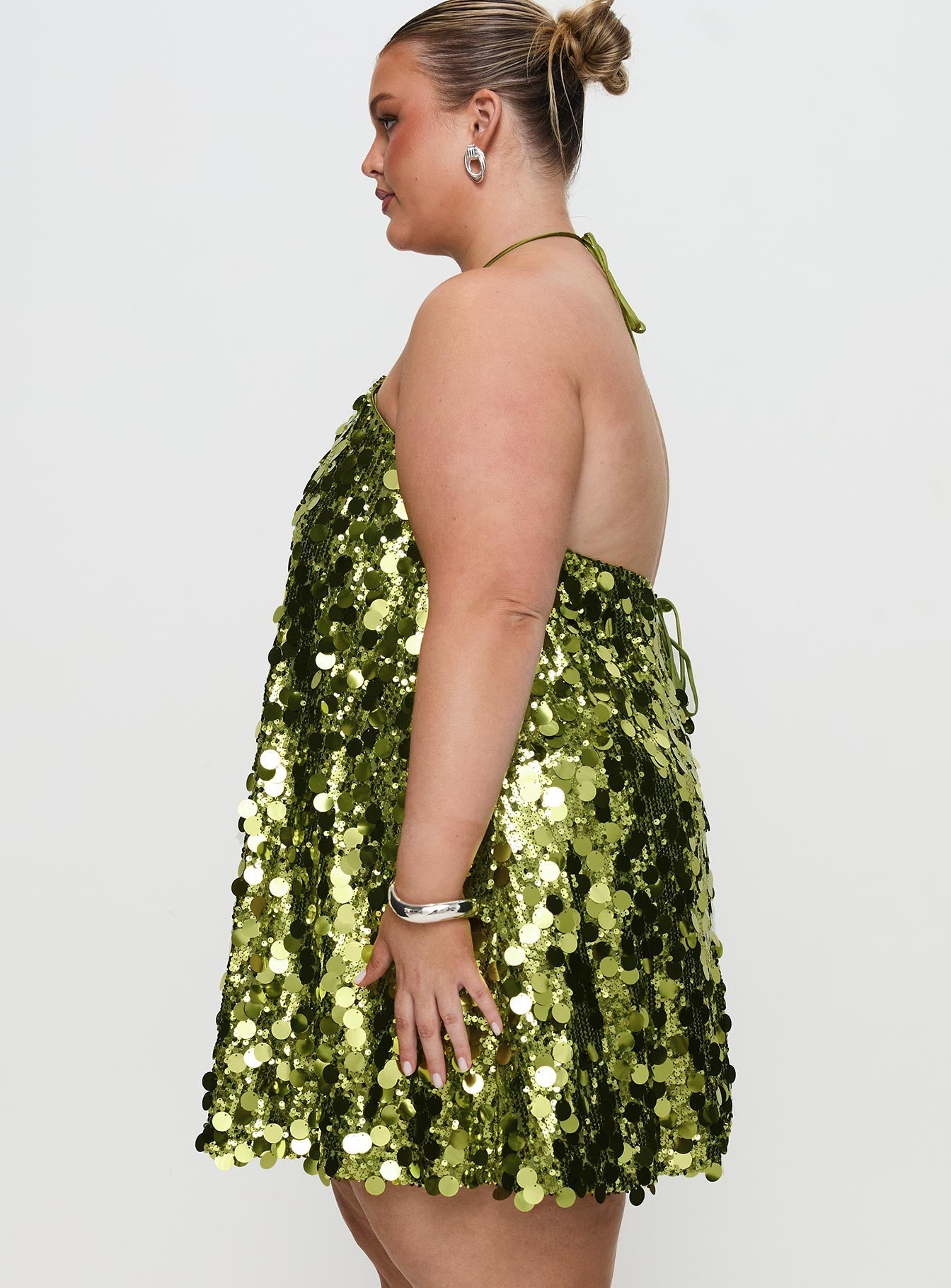 side view of model wearing Princess Polly Fluorescents Halter Mini Dress Green Curve Asymmetric Neckline 