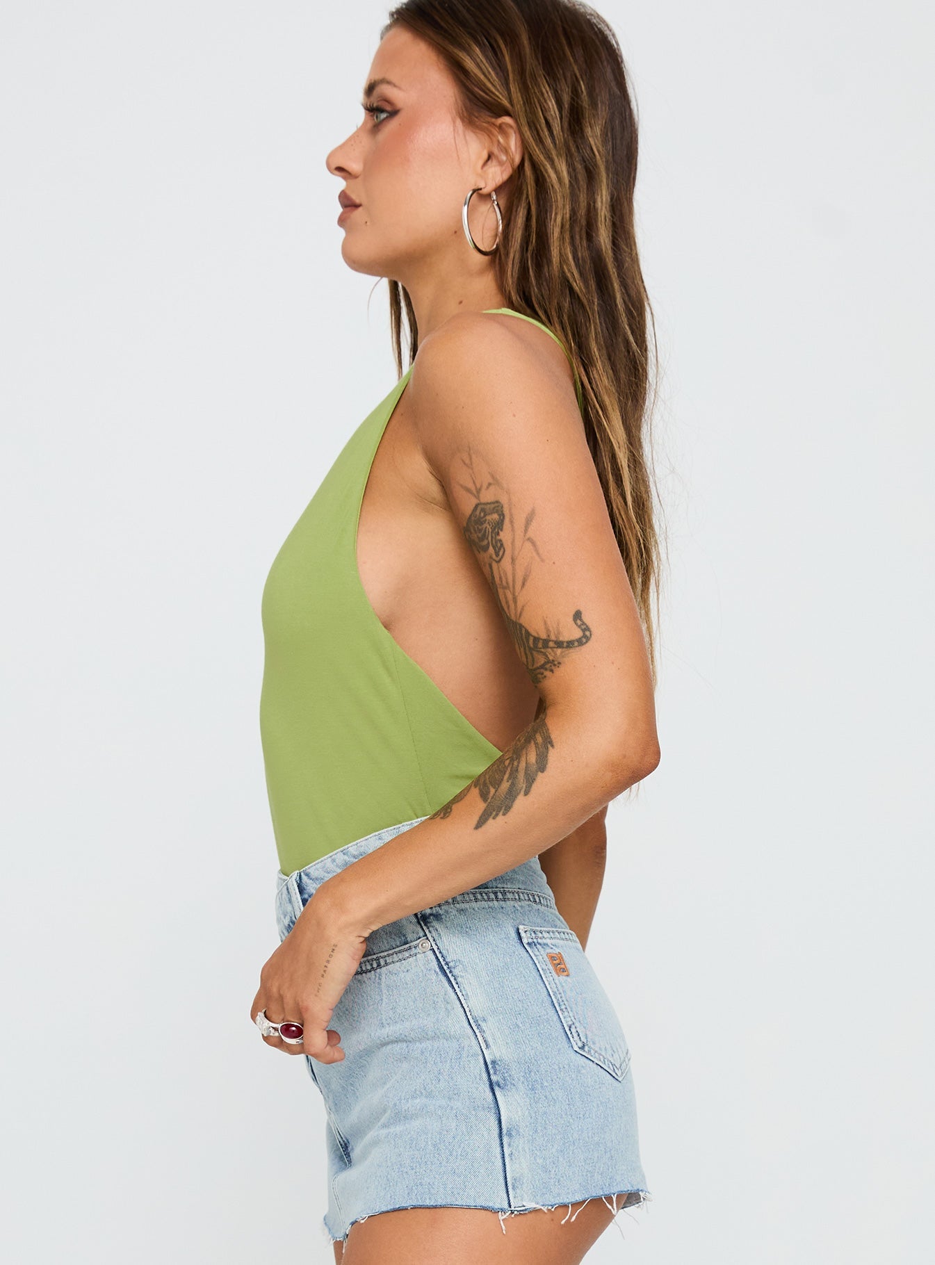 side view of model wearing Princess Polly Ferrera One Shoulder Bodysuit Green Sleeveless 