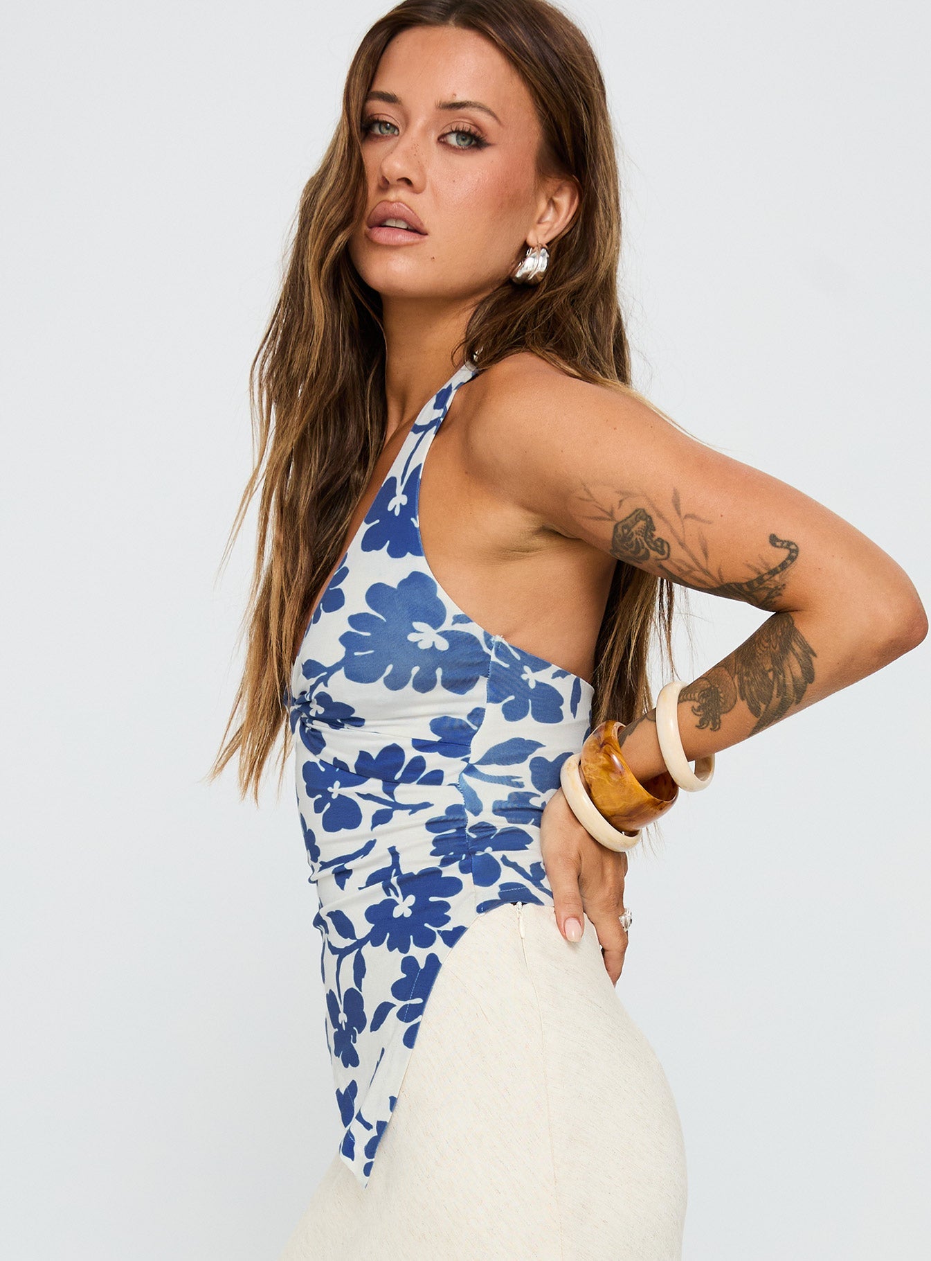 side view of model wearing Princess Polly Chilli Halter Top Blue Floral Sleeveless Plunger 