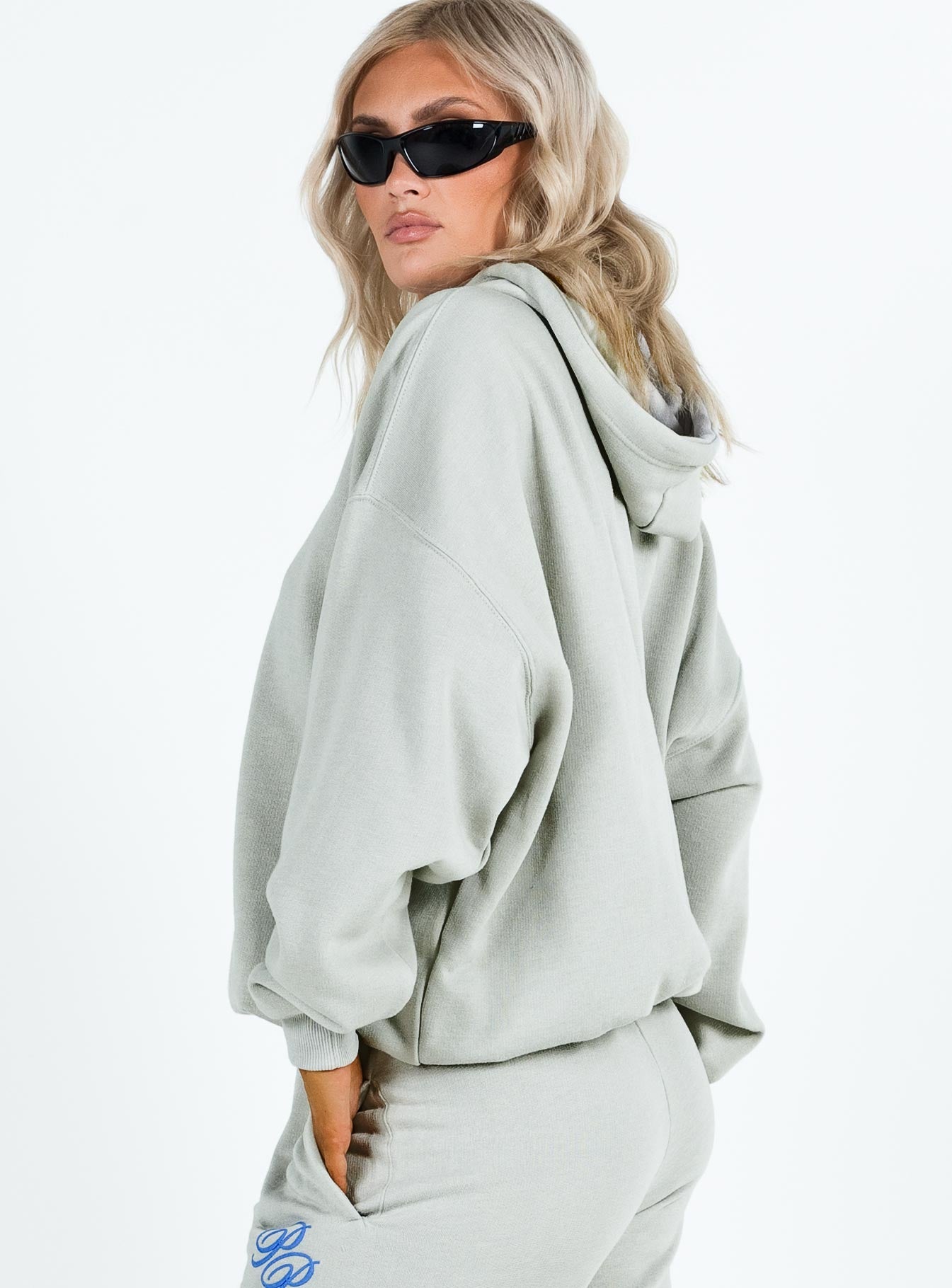 side view of model wearing Princess Polly Princess Polly Hooded Sweatshirt Cursive Text Grey / Blue regular 