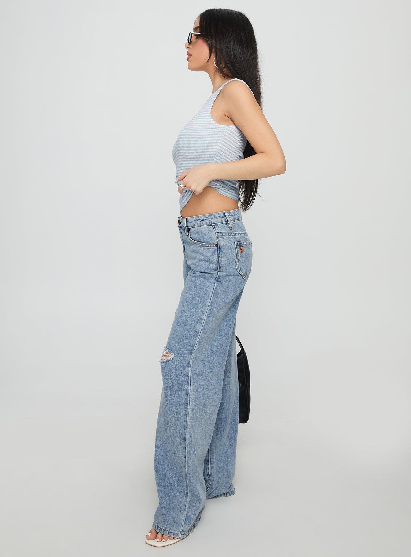 side view of model wearing Princess Polly Kadison Low Rise Straight Leg Jeans Mid Wash Blue Low Rise Jeans 