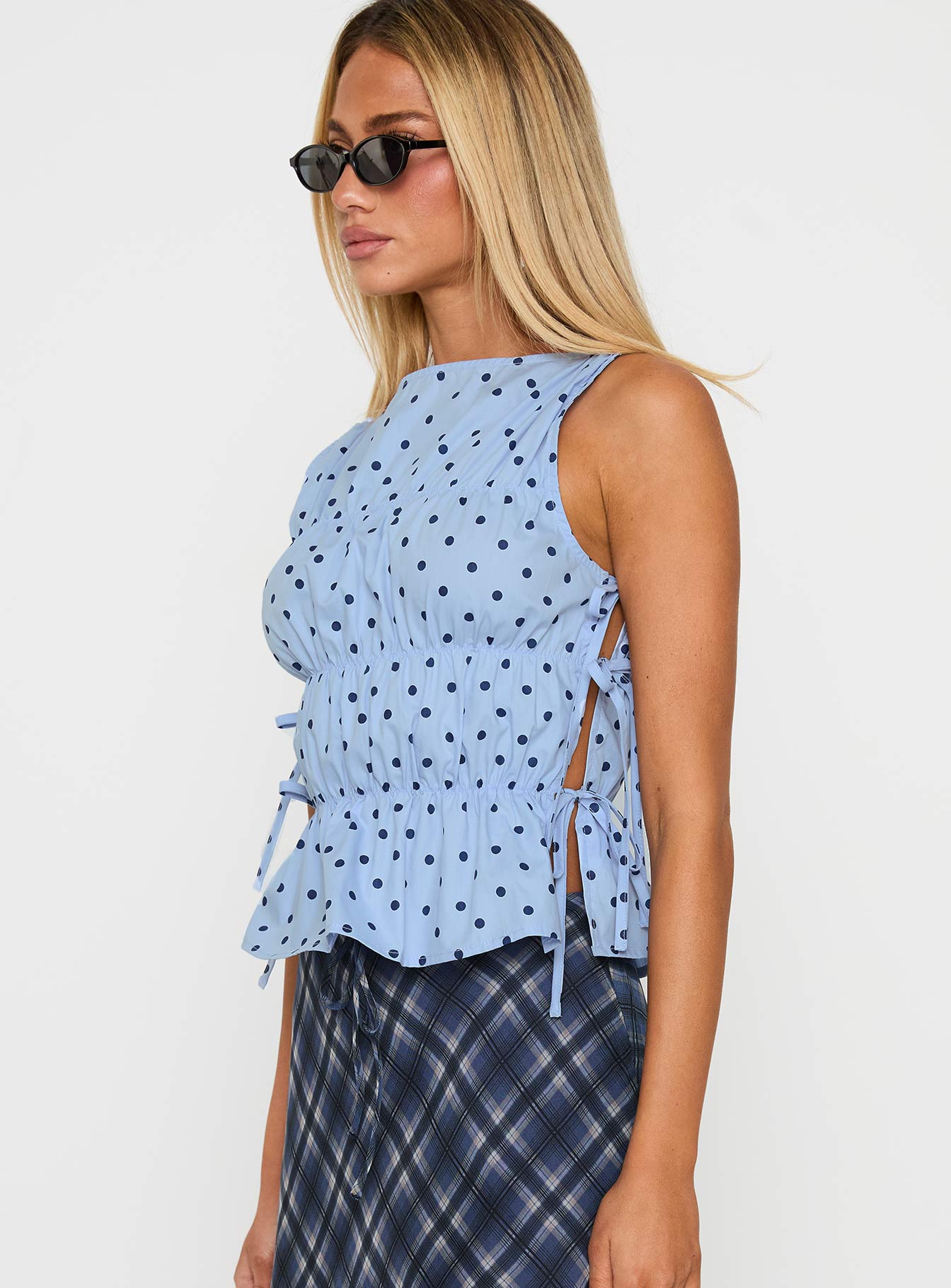 side view of model wearing Princess Polly Endless Summers Tie Side Top Blue Polka Dot Sleeveless Boat Neck 