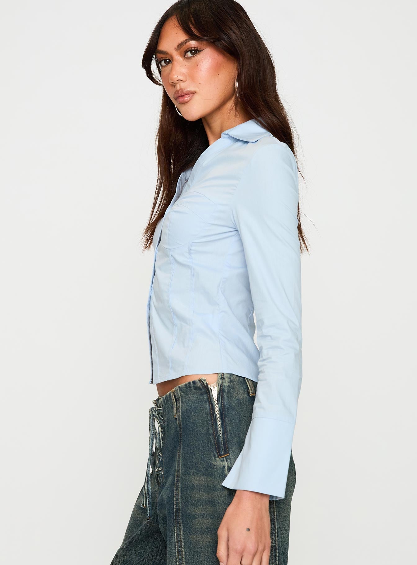 side view of model wearing Princess Polly Zifa Shirt Blue Full Sleeves V-Neck 