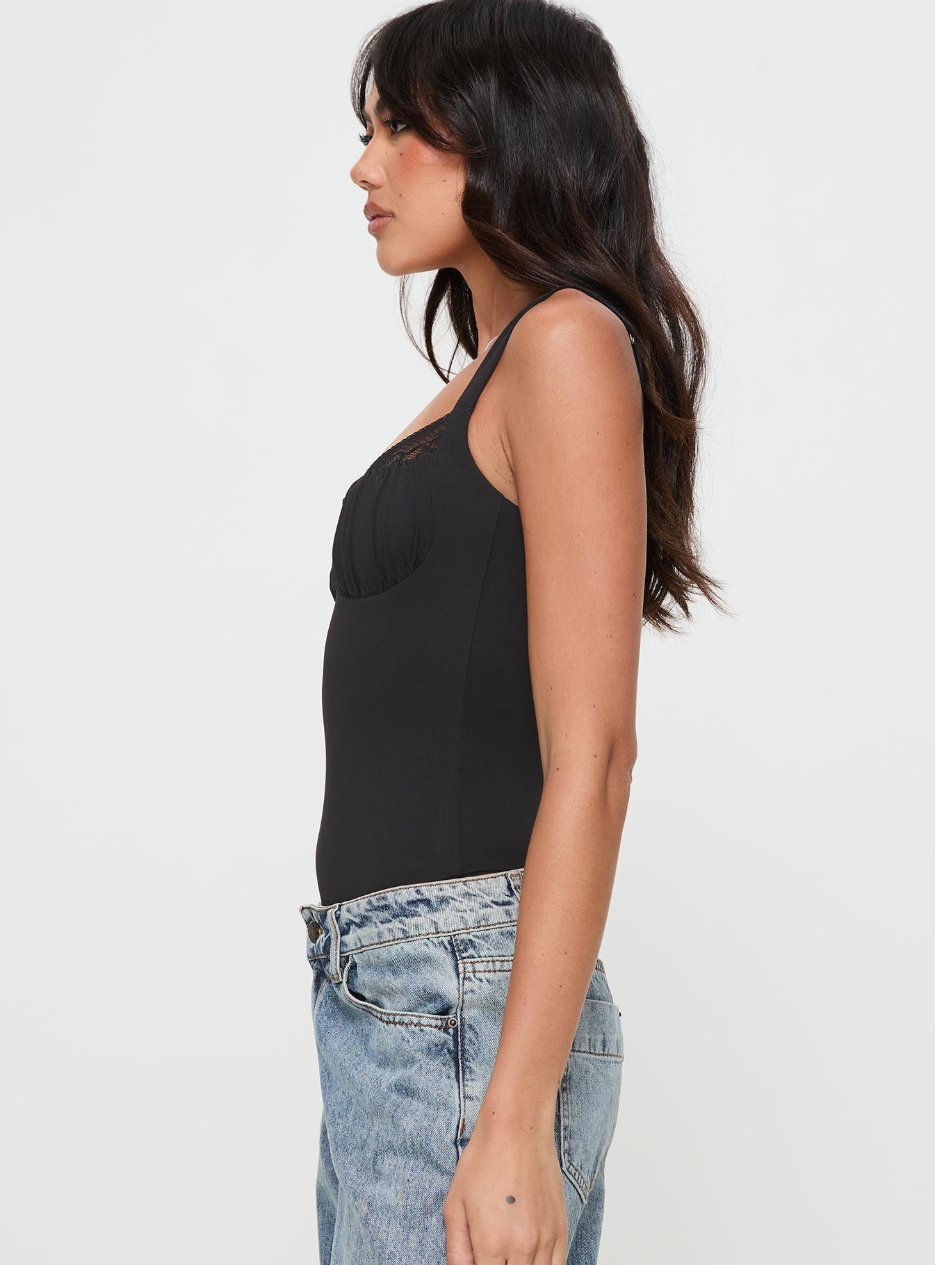 side view of model wearing Princess Polly Peekaboo Bodysuit Black Sleeveless 