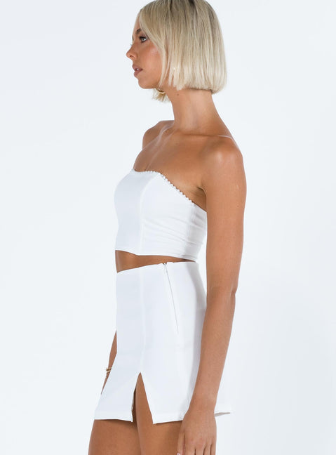 White two piece set Strapless crop top Pearl embellishments at bust Boning through bust Invisible zip fastening at back  Mini skirt Side split Invisible zip fastening at side