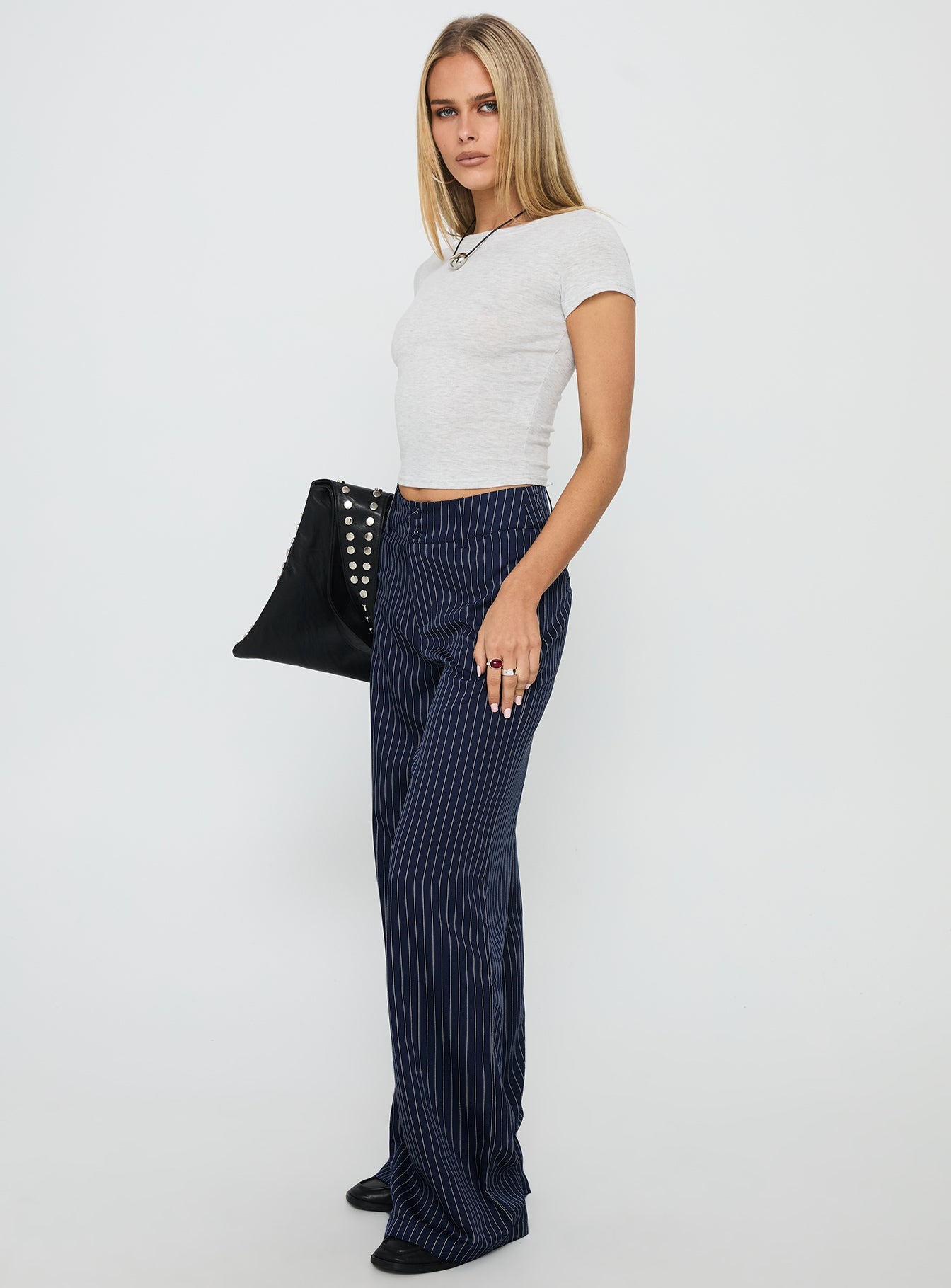 side view of model wearing Princess Polly Lorenne Mid Rise Pant Navy Pinstripe High Waisted Pants 
