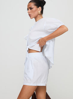 side view of model wearing Princess Polly Sunblind Shorts White High Waisted Shorts 