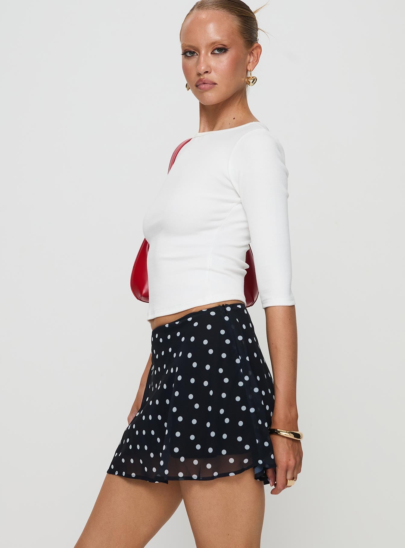   side view of model wearing Princess Polly Dapple Bias Mini Skirt Black Polka Dot Mini Skirts 