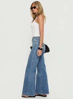side view of model wearing Princess Polly Thearlie High Rise Flared Jeans Mid Blue Wash High Rise Jeans 