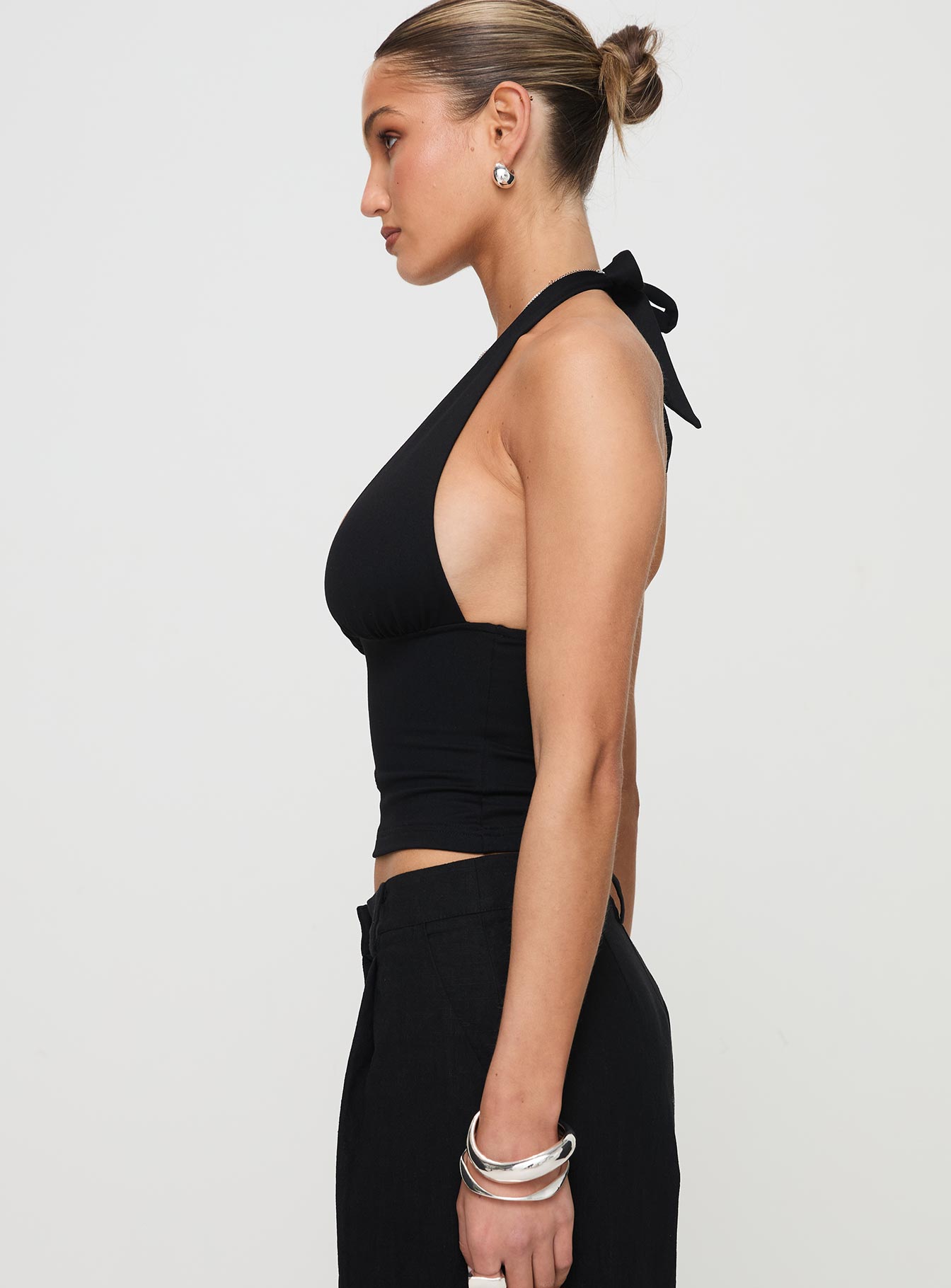 side view of model wearing Princess Polly Whimsy Halter Top Black Sleeveless Plunger 