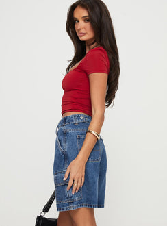 side view of model wearing Princess Polly Mika Carpenter Denim Shorts Mid Wash Petite High Waisted Shorts Low Rise Shorts 