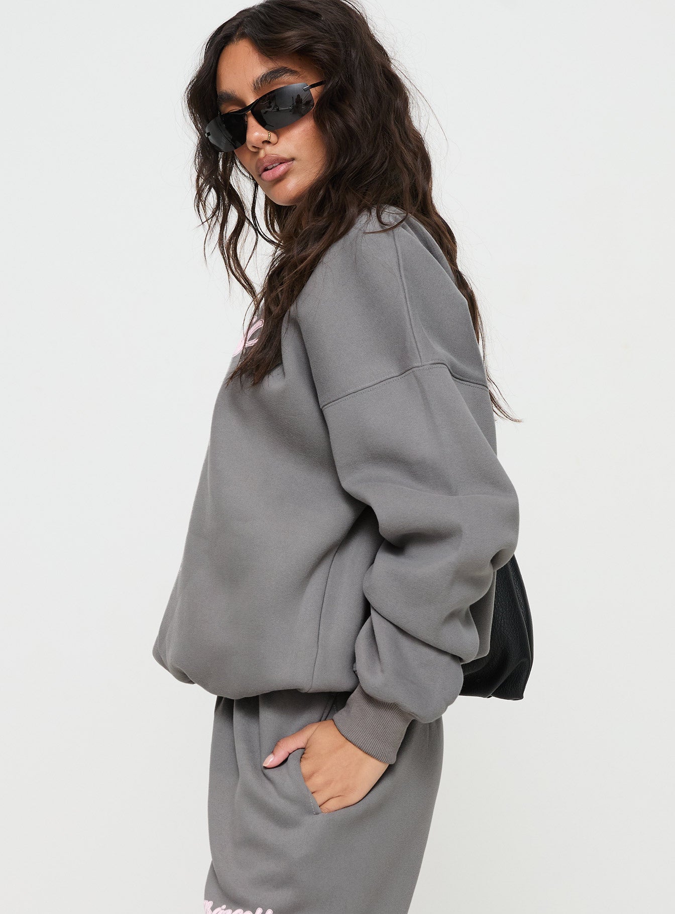 side view of model wearing Princess Polly Princess Polly Crew Neck Sweatshirt Puff Text Charcoal Long 