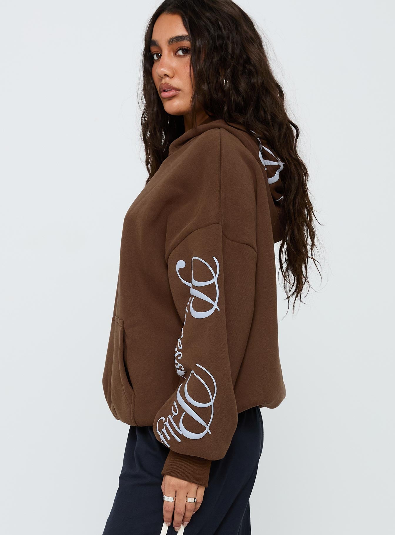 side view of model wearing Princess Polly Princess Polly Script Text Graphic Hoodie Brown / Blue Long 