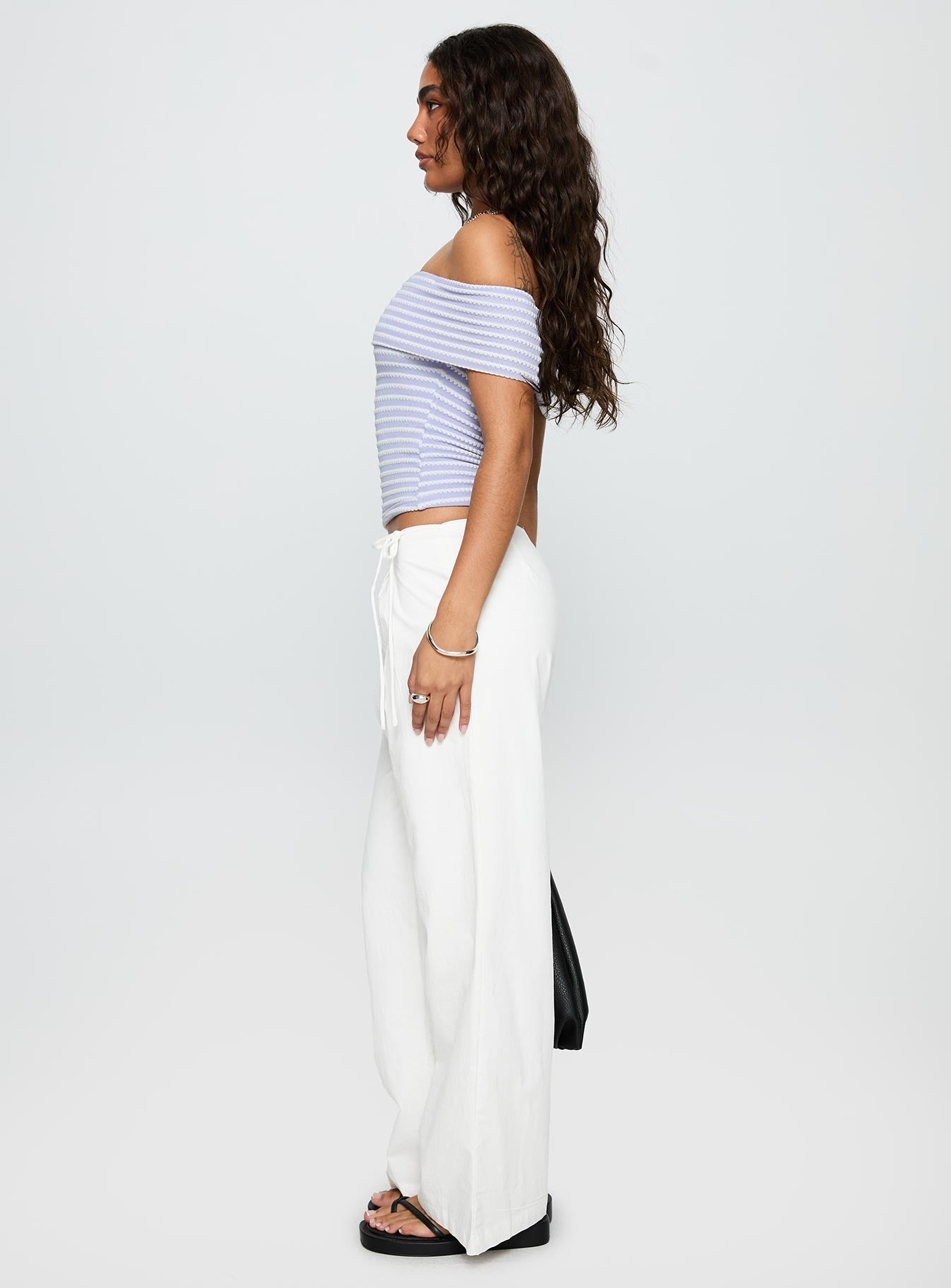 side view of model wearing Princess Polly Leyah Tie Side Pants White Low Rise Pants 