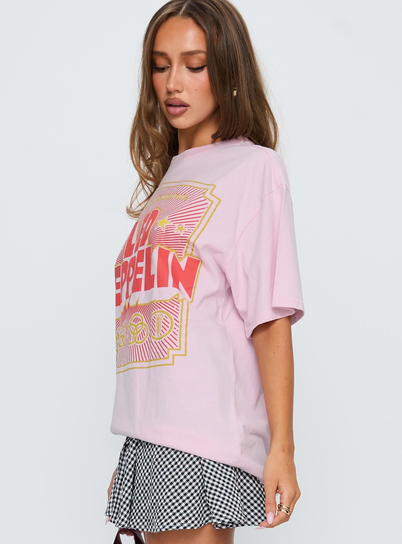 side view of model wearing Princess Polly Led Zeppelin Oversized Vintage Graphic Top Pink Half Sleeves Crew Neck 