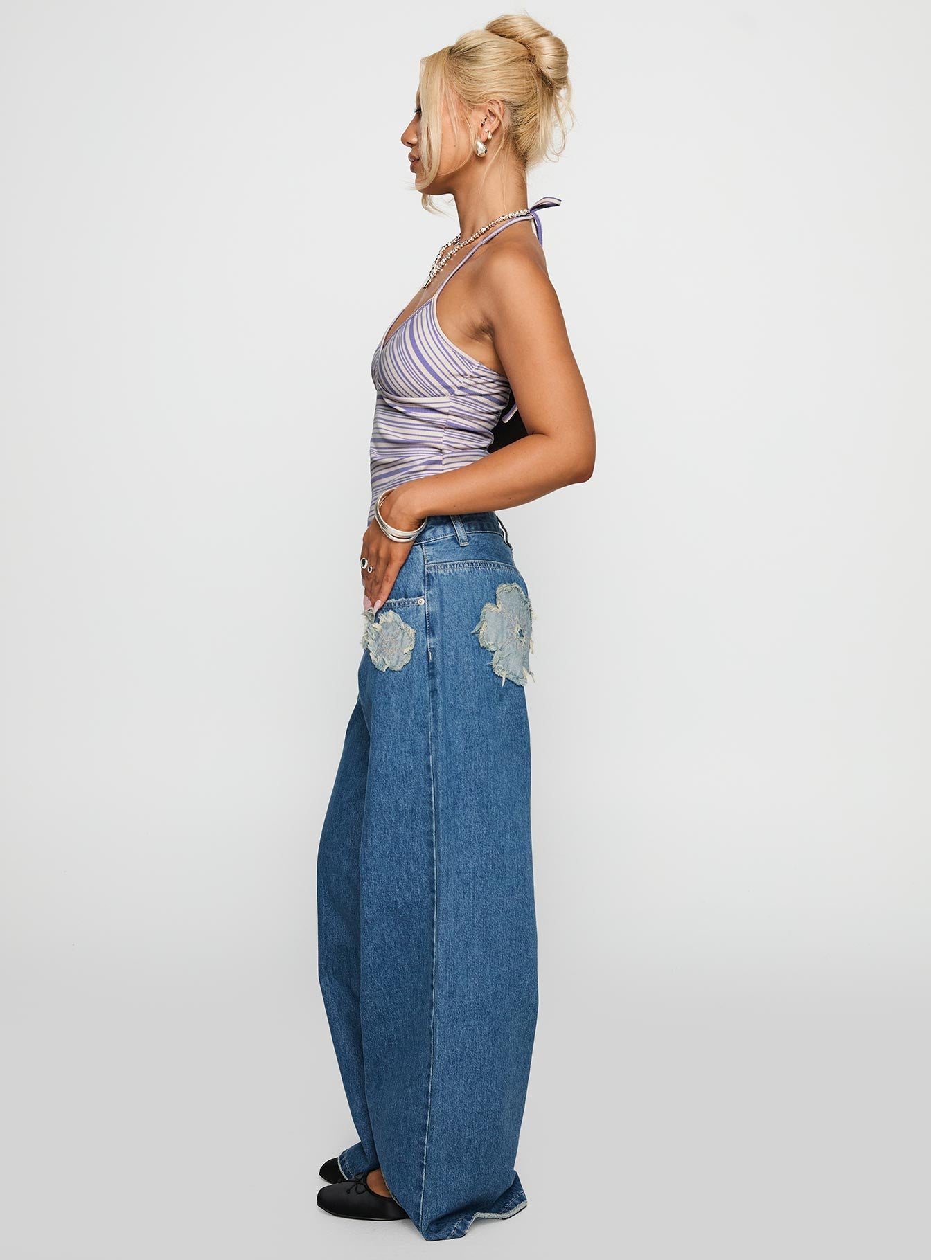 side view of model wearing Princess Polly A Keeper Flower Patch Jeans Mid Blue Low Rise Jeans 