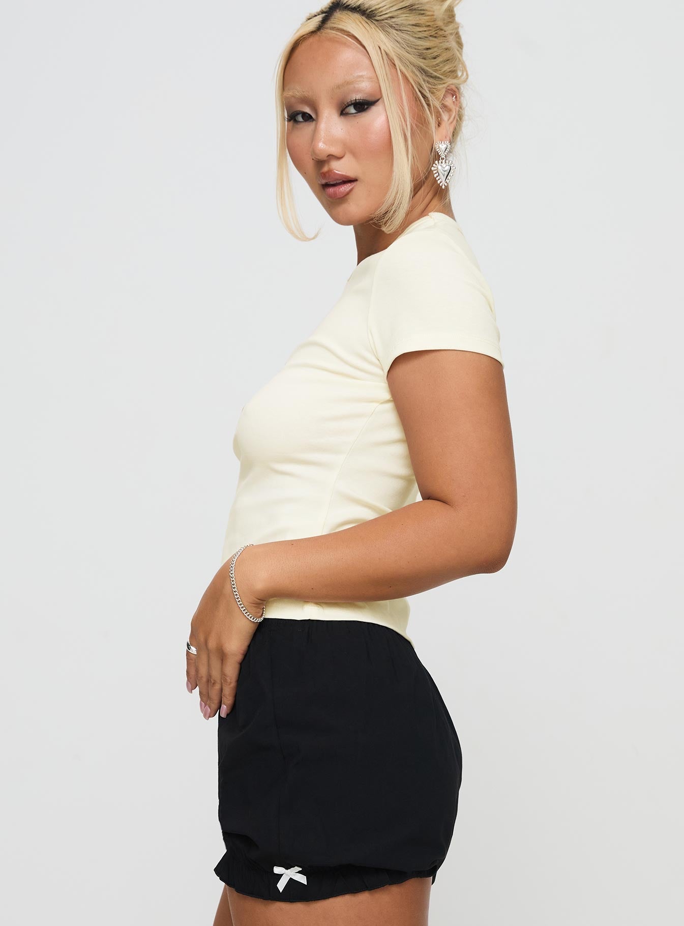 side view of model wearing Princess Polly Marseille Manners Graphic Top Cream Short Sleeves High Neck 