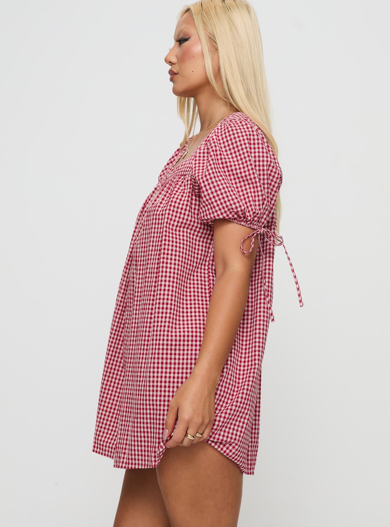 side view of model wearing Princess Polly Lilibet Mini Dress Red Gingham Square Neck 