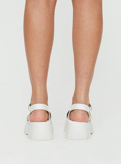 Sandals Strappy upper, faux leather, silver-toned hardware, buckle fastening, platform base,        treaded sole, rounded toe
