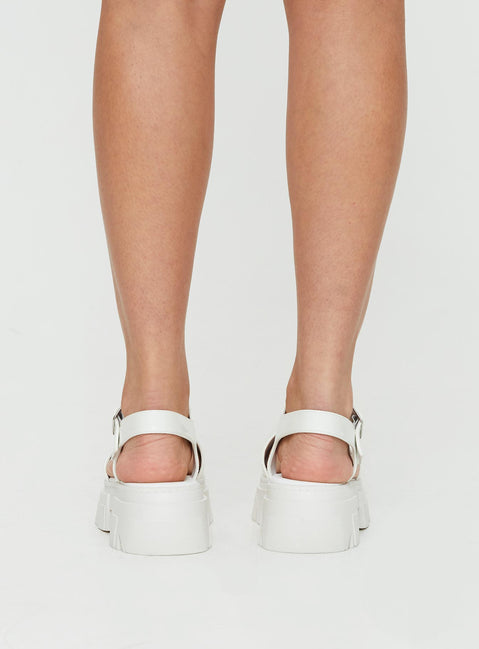 Sandals Strappy upper, faux leather, silver-toned hardware, buckle fastening, platform base,        treaded sole, rounded toe