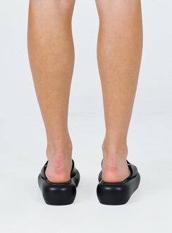 Black sandals Faux leather material Single wide upper Padded footbed Platform base