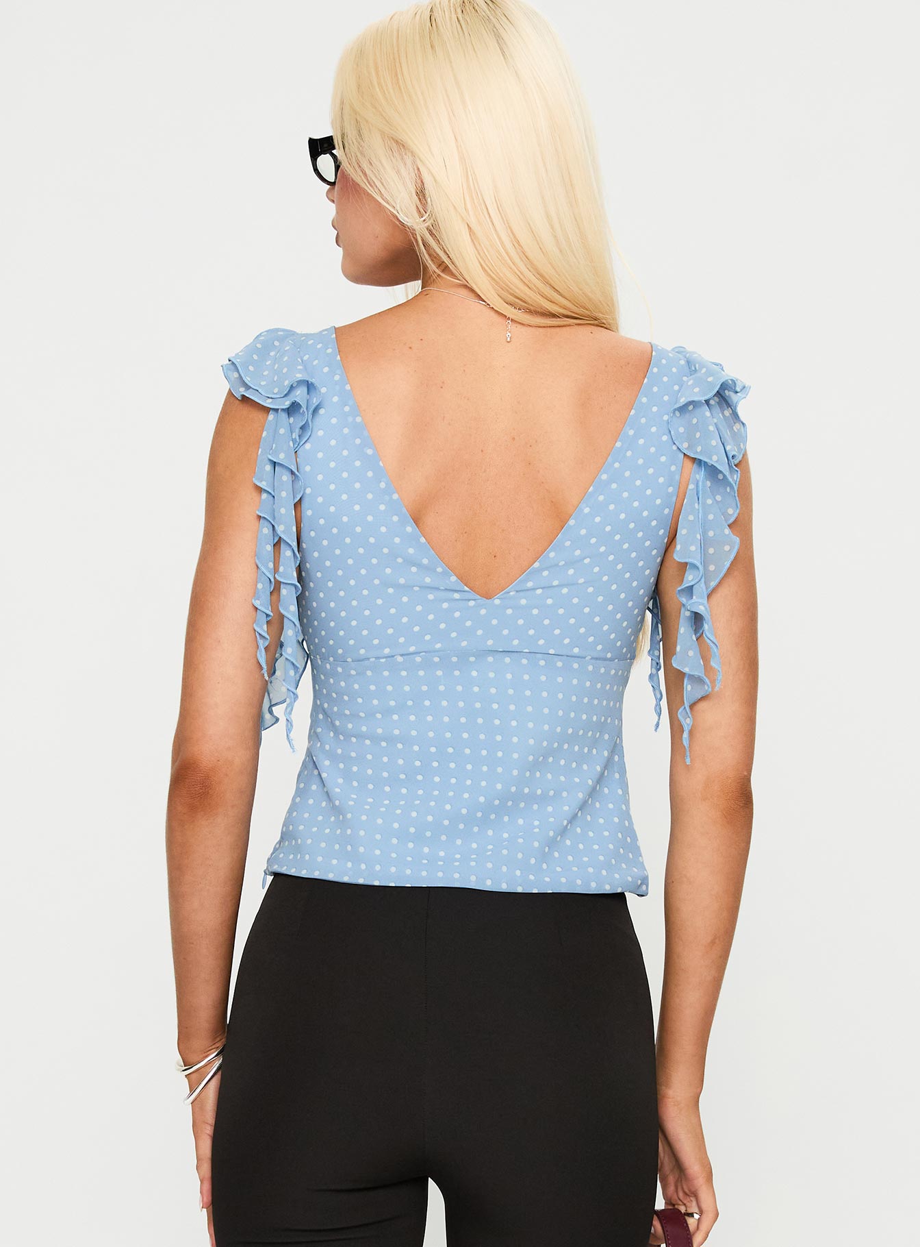back view of model wearing Princess Polly Miztry Top Blue Polka Sleeveless Plunger 