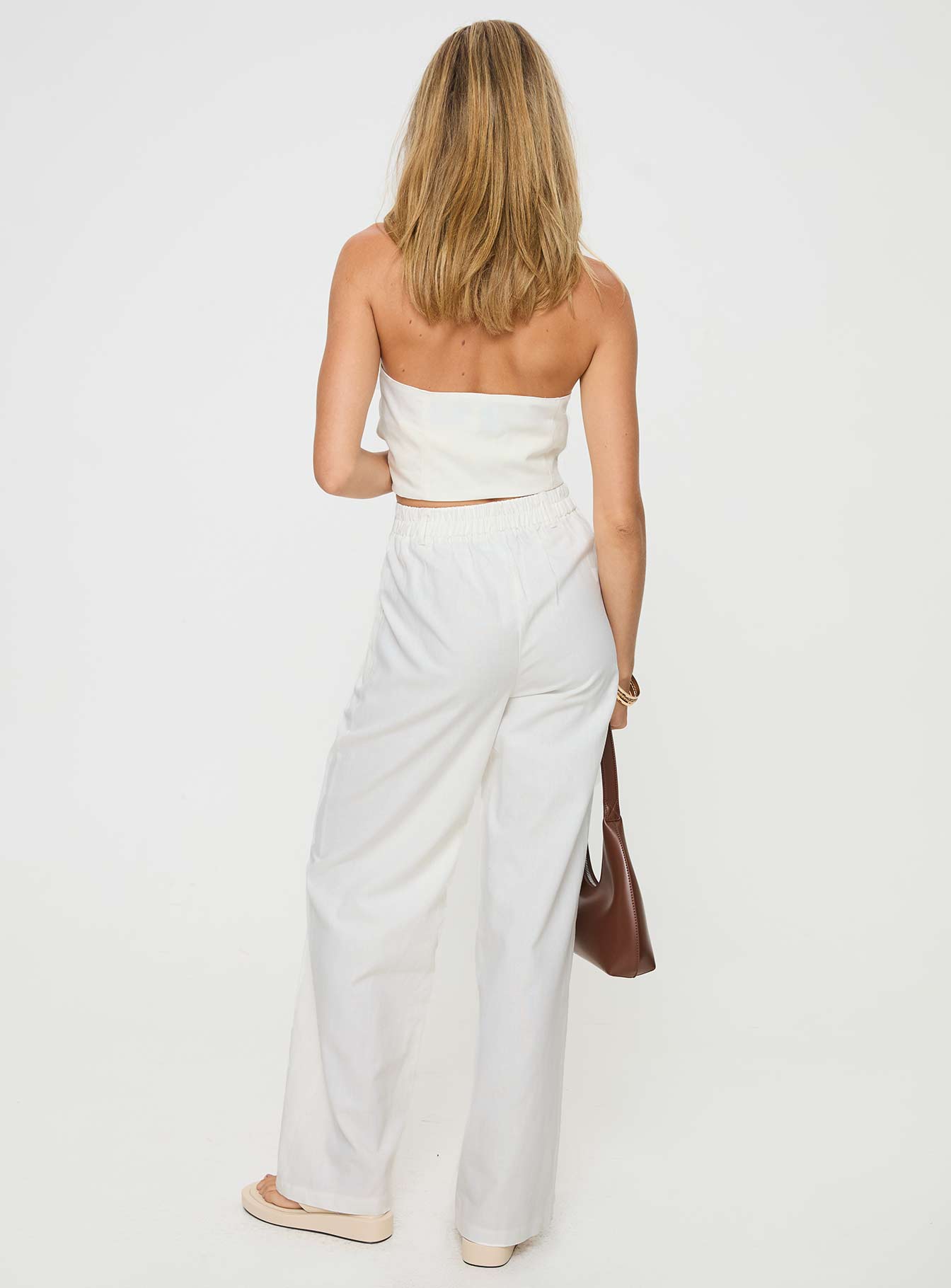 White Matching linen set Halter neck top, fixed halter strap, button fastening at front, twin hip pockets High rise pants, belt looped waist, zip and button fastening, elasticated waistband at back, twin hip pockets, straight leg