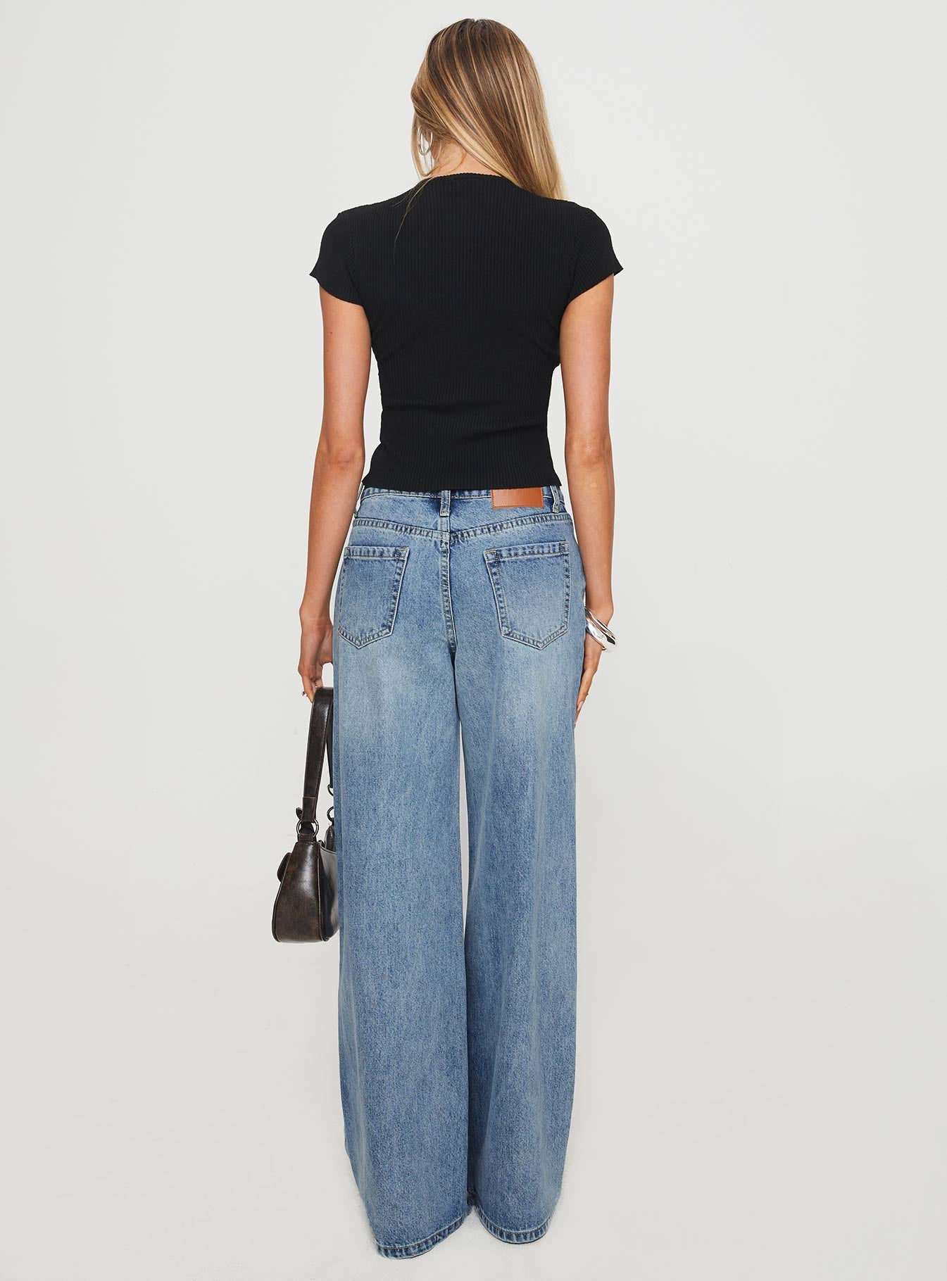 back view of model wearing Princess Polly Mellowed Out Slouchy Jeans Mid Blue High Waisted 