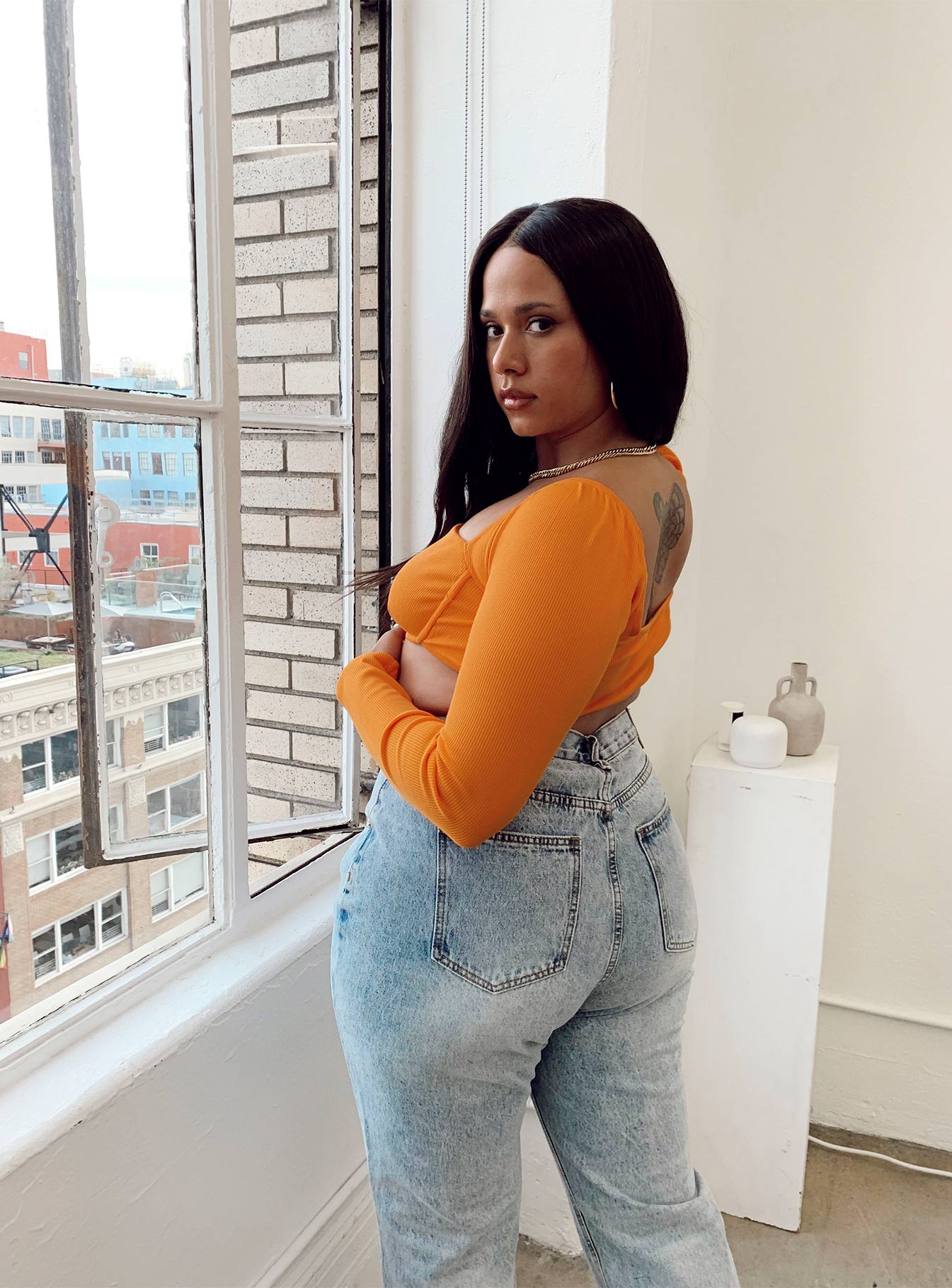 side view of model wearing Princess Polly Becca Long Sleeve Crop Top Orange Curve 