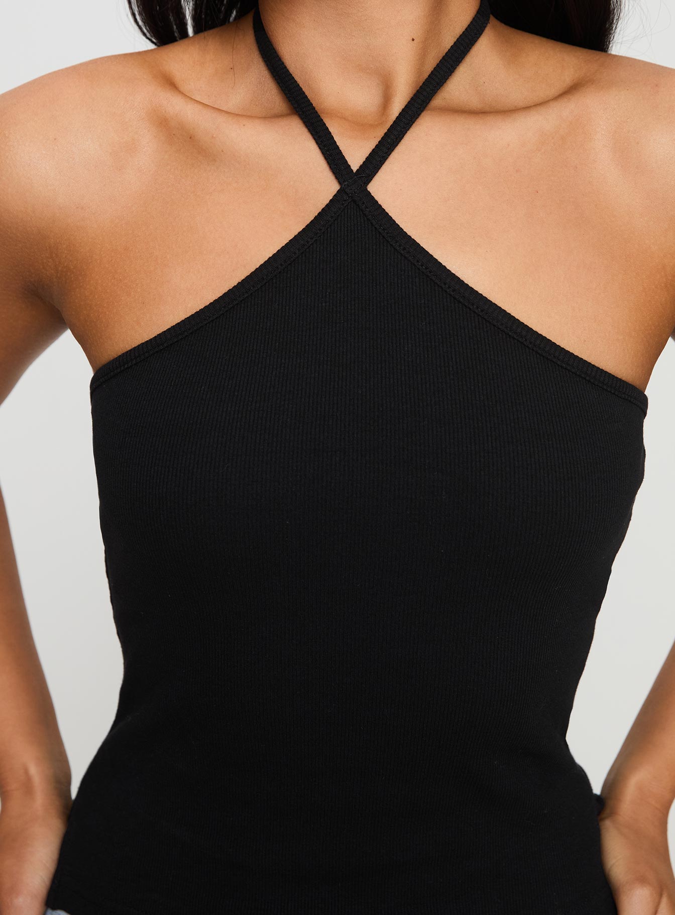 back view of model wearing Princess Polly Baseline Halter Rib Top Black Sleeveless 