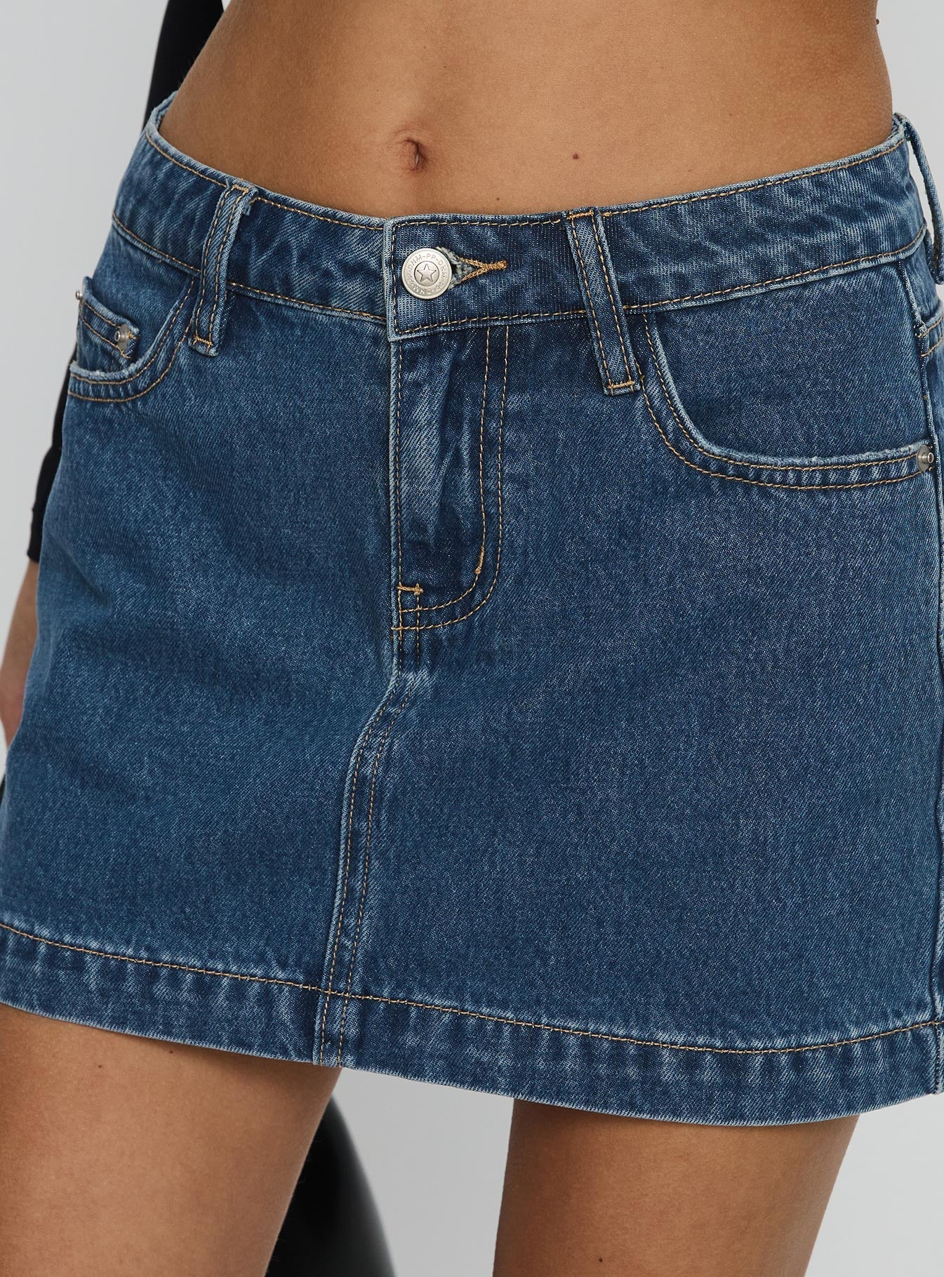   side view of model wearing Princess Polly Nickei Denim Mini Skirt Mid Wash Tall Mini Skirts 