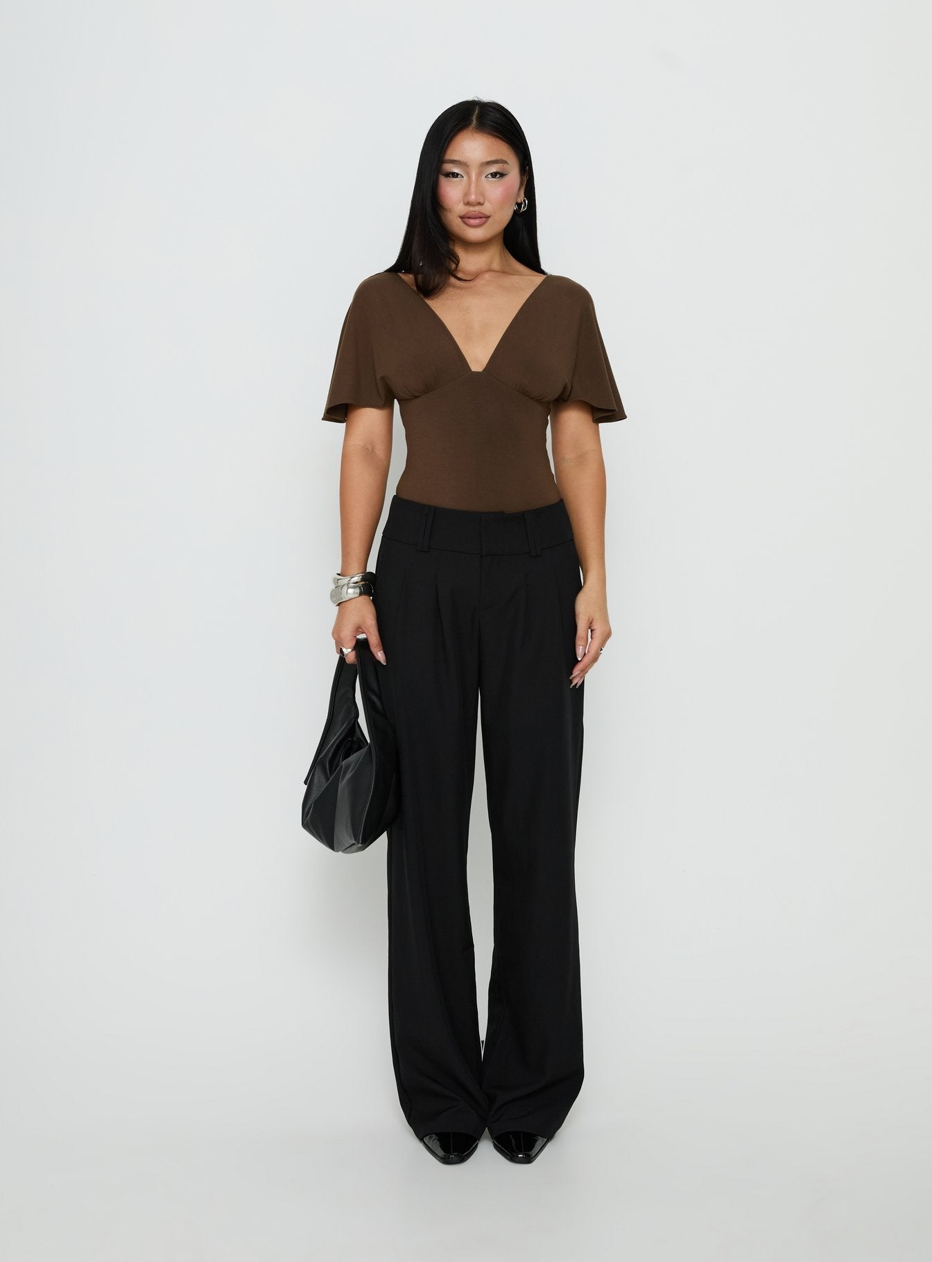Crafted from saddle brown fabric, the Yevenna Batwing Plunge Bodysuit Chocolate womens-bodysuit features short sleeves product Princess Polly