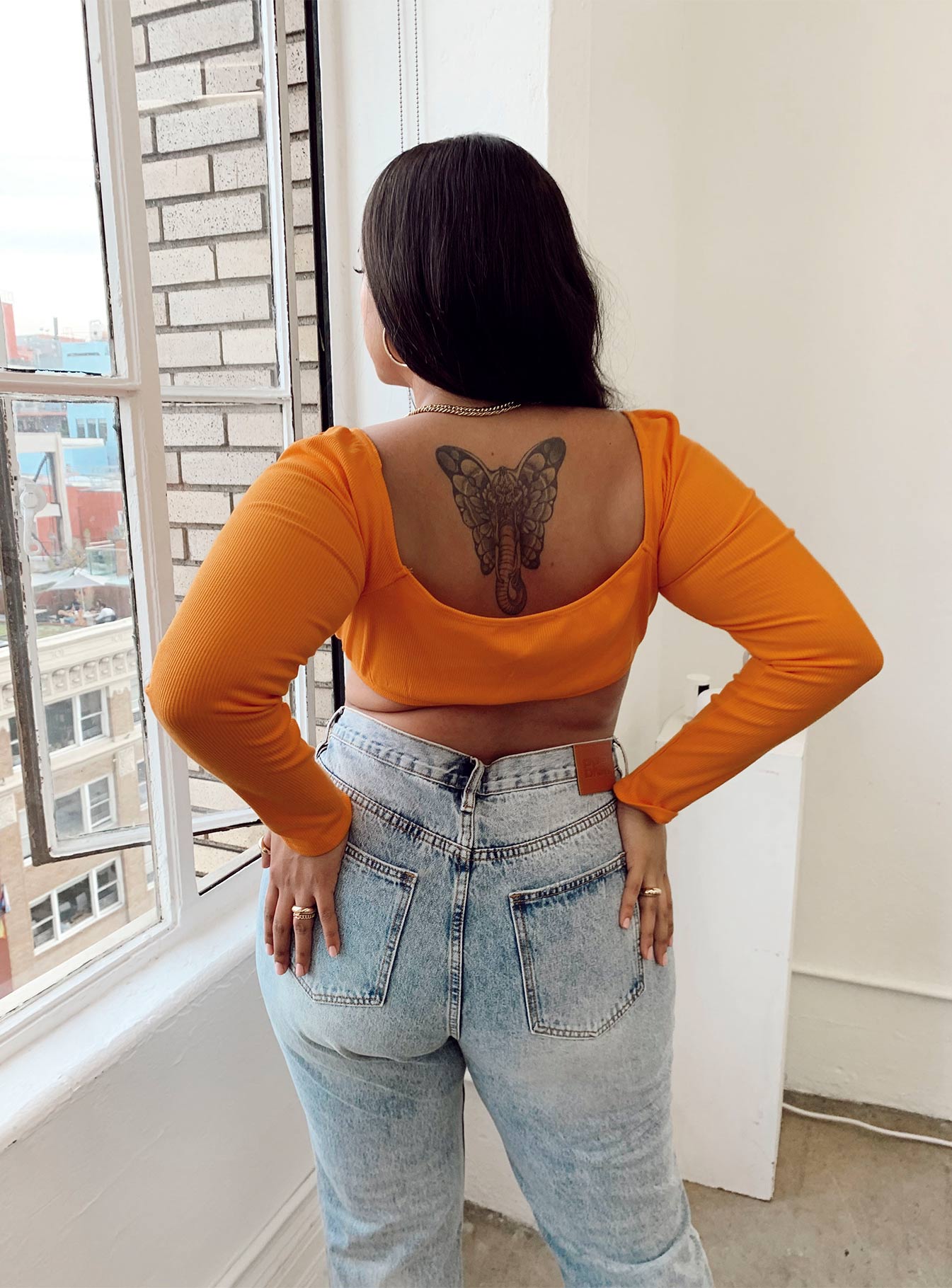 back view of model wearing Princess Polly Becca Long Sleeve Crop Top Orange Curve 