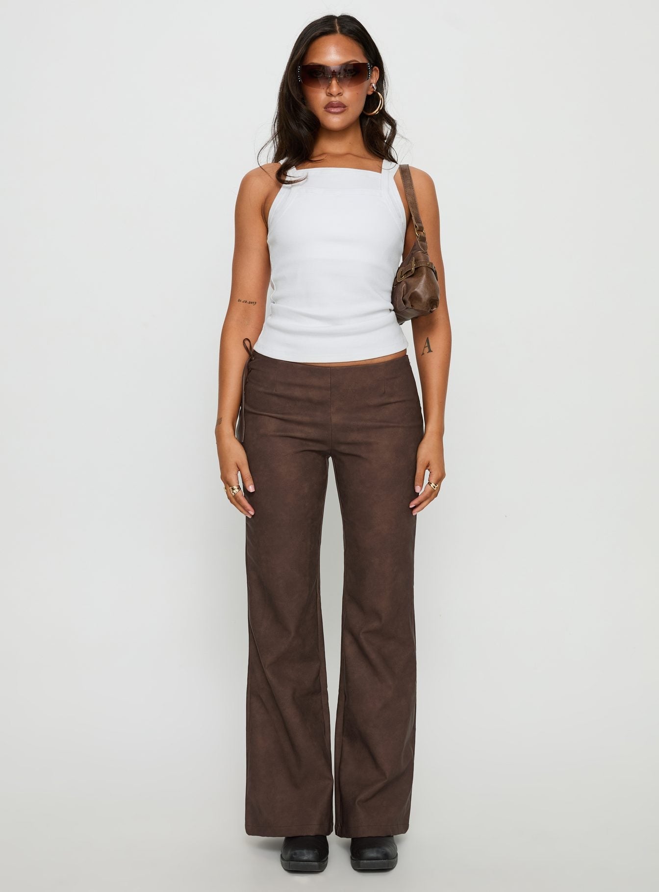 front view of model wearing Princess Polly Trickrider Tie Side Faux Leather Pants Chocolate Mid Rise Pants 