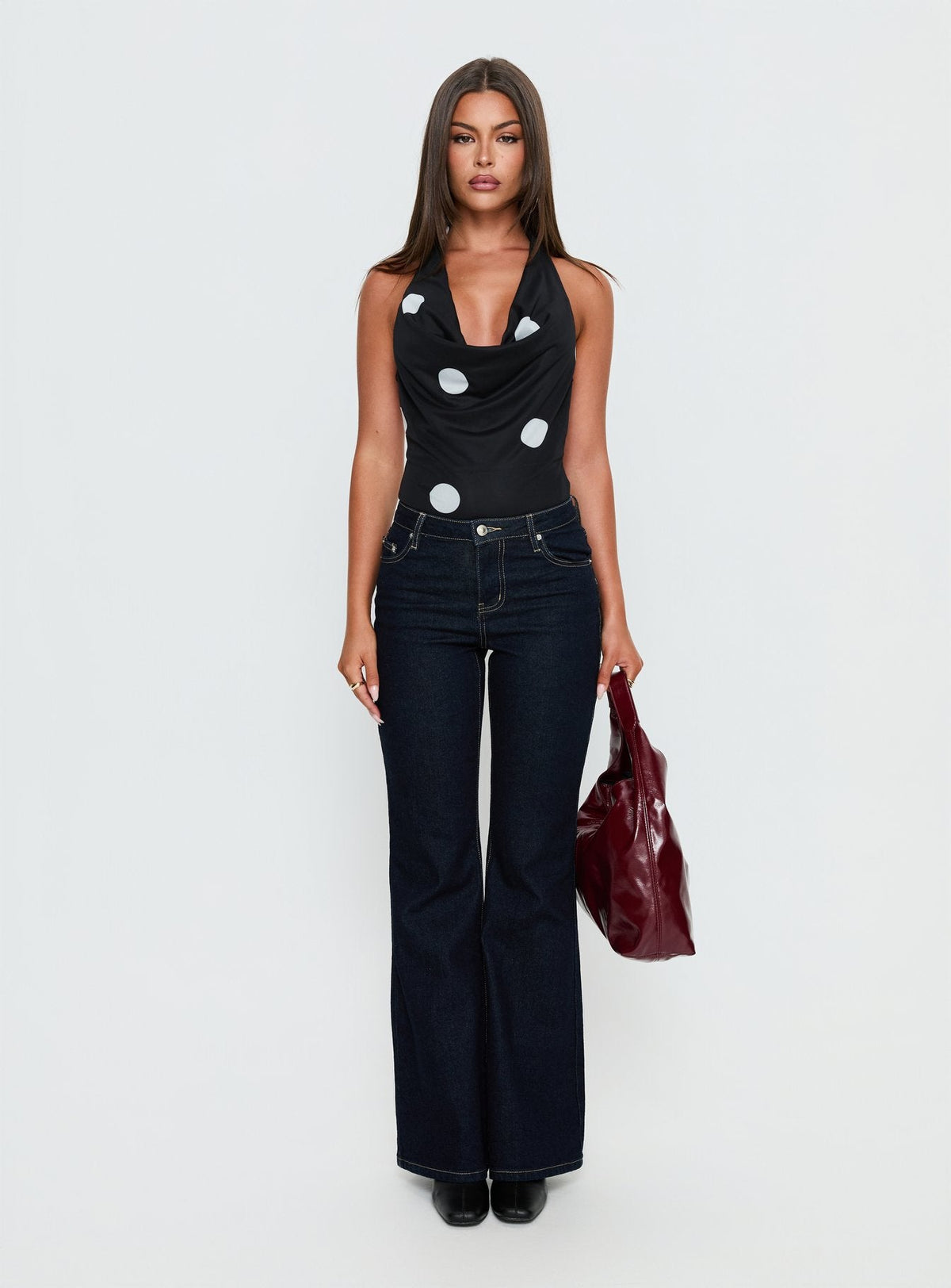 front view of model wearing Princess Polly Cleona Plunge Neck Bodysuit Black Polka Sleeveless Bodysuit 