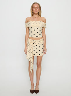   side view of model wearing Princess Polly Porzia Wrap Detail Mini Skirt Cream / Polka Dot Mini Skirts 
